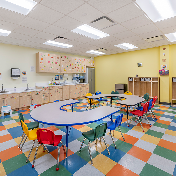 Sala de aprendizaje con mesas y sillas para estudiantes.