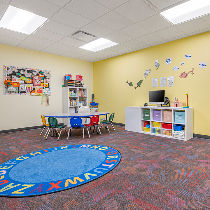 Sala de aprendizaje con mesas y sillas para estudiantes.